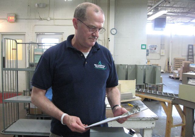 man reviewing a clipboard in a kitchen